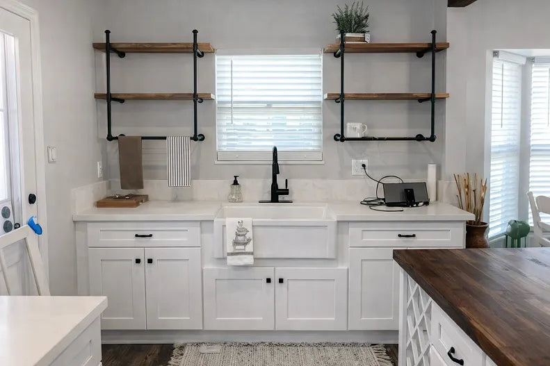 Farm sink cabinet with floating shelves. Equal sized cabinets each side of sink.